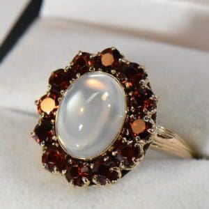 retro moonstone cocktail ring with garnet halo circa 1945.JPG