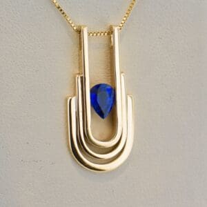 modern art deco style heavy gold and blue sapphire pendant